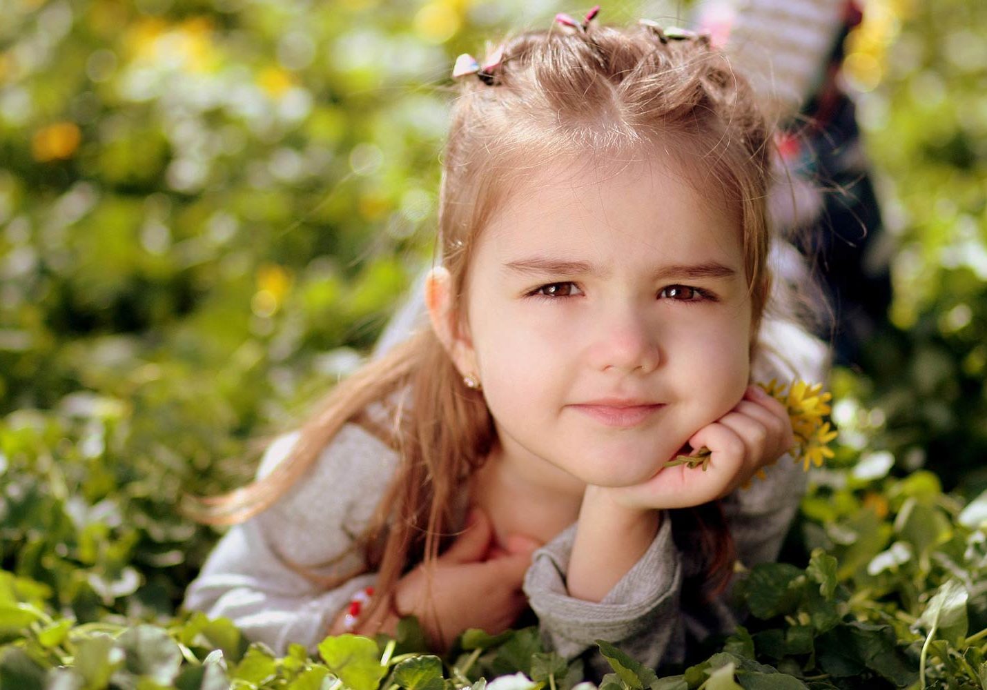 Girl laying in a field clutching flowers